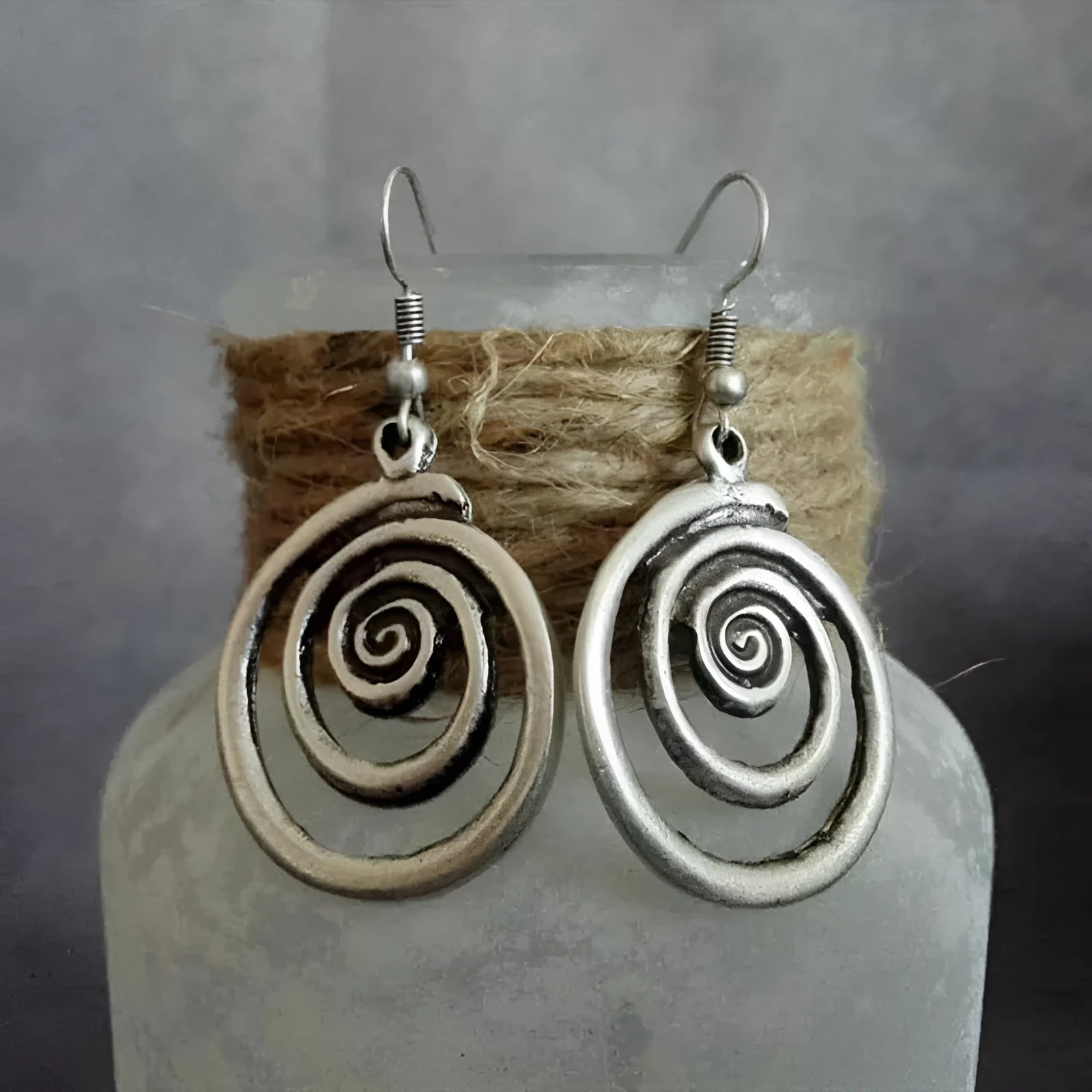 Silver geometric spiral earrings with distressed finish showing 2.6cm width and 5cm length