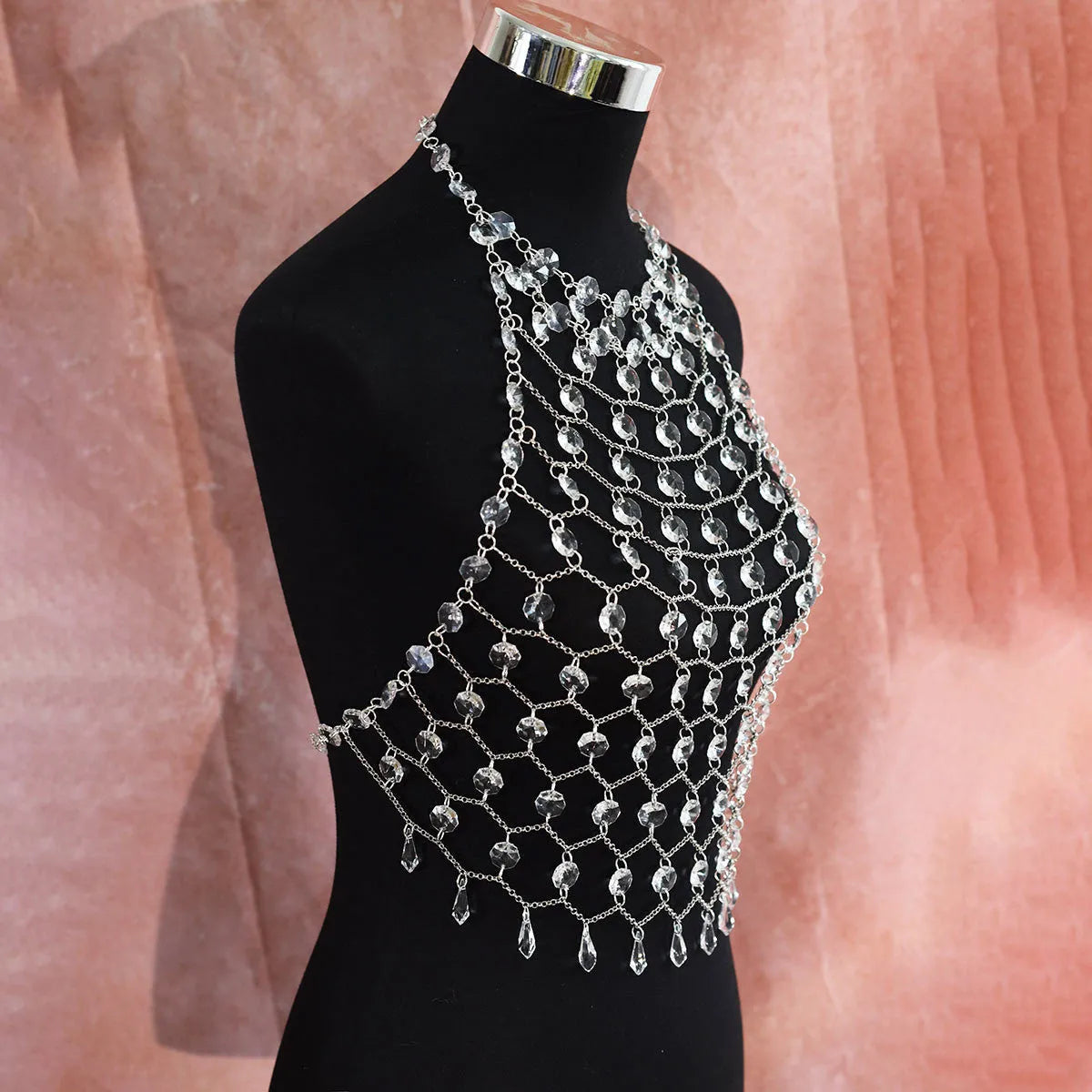 Hand-woven transparent acrylic sequinned plastic resin body chain draped flat.
