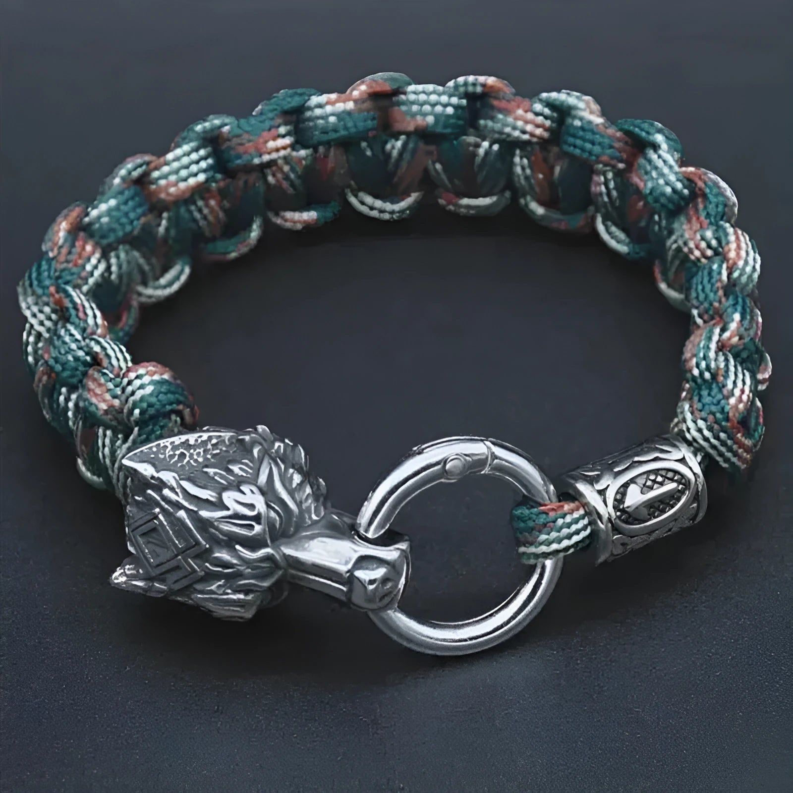 Handmade titanium steel wolf head bracelet in camouflage colour on a wrist.