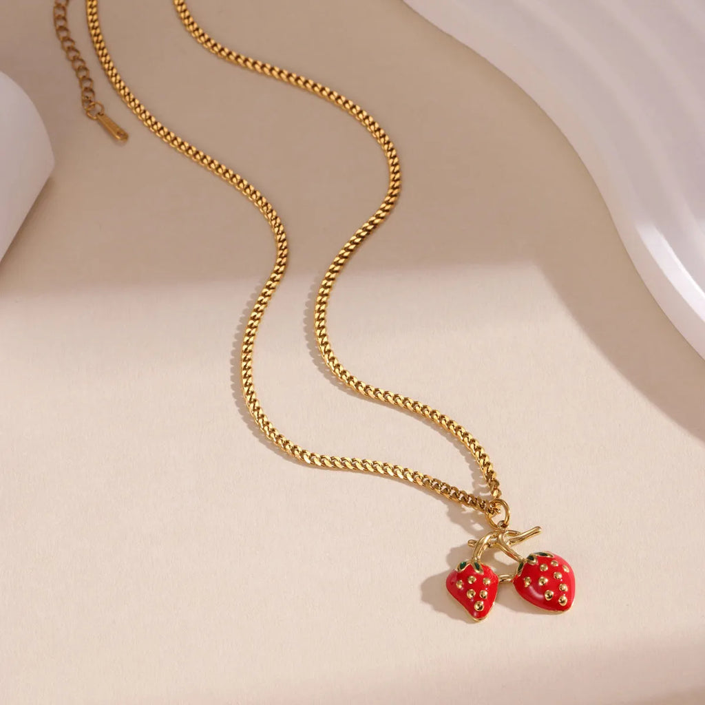 Women's strawberry fruit pendant necklace in red and white gradient colours on an alloy chain.