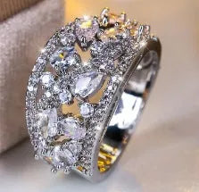 Women's hollow round copper fashion ring with gemstone, shown in gold and platinum colour options.
