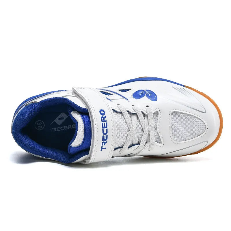 Lightweight white and blue badminton shoes with ribbed sole on an indoor court.