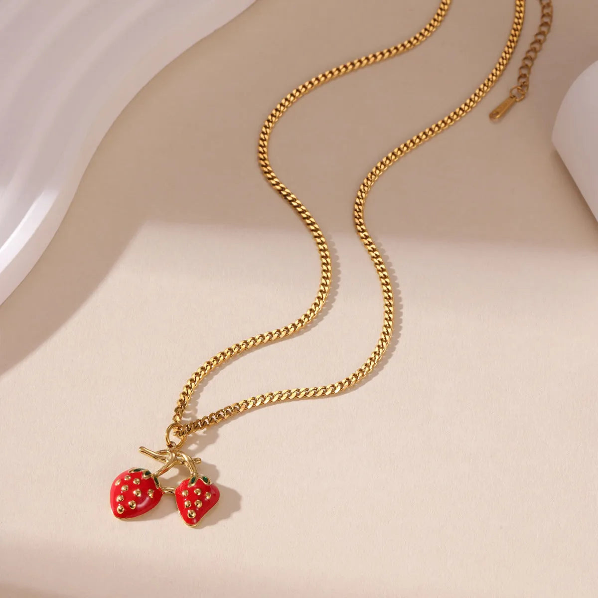 Women's strawberry fruit pendant necklace in red and white gradient colours on an alloy chain.