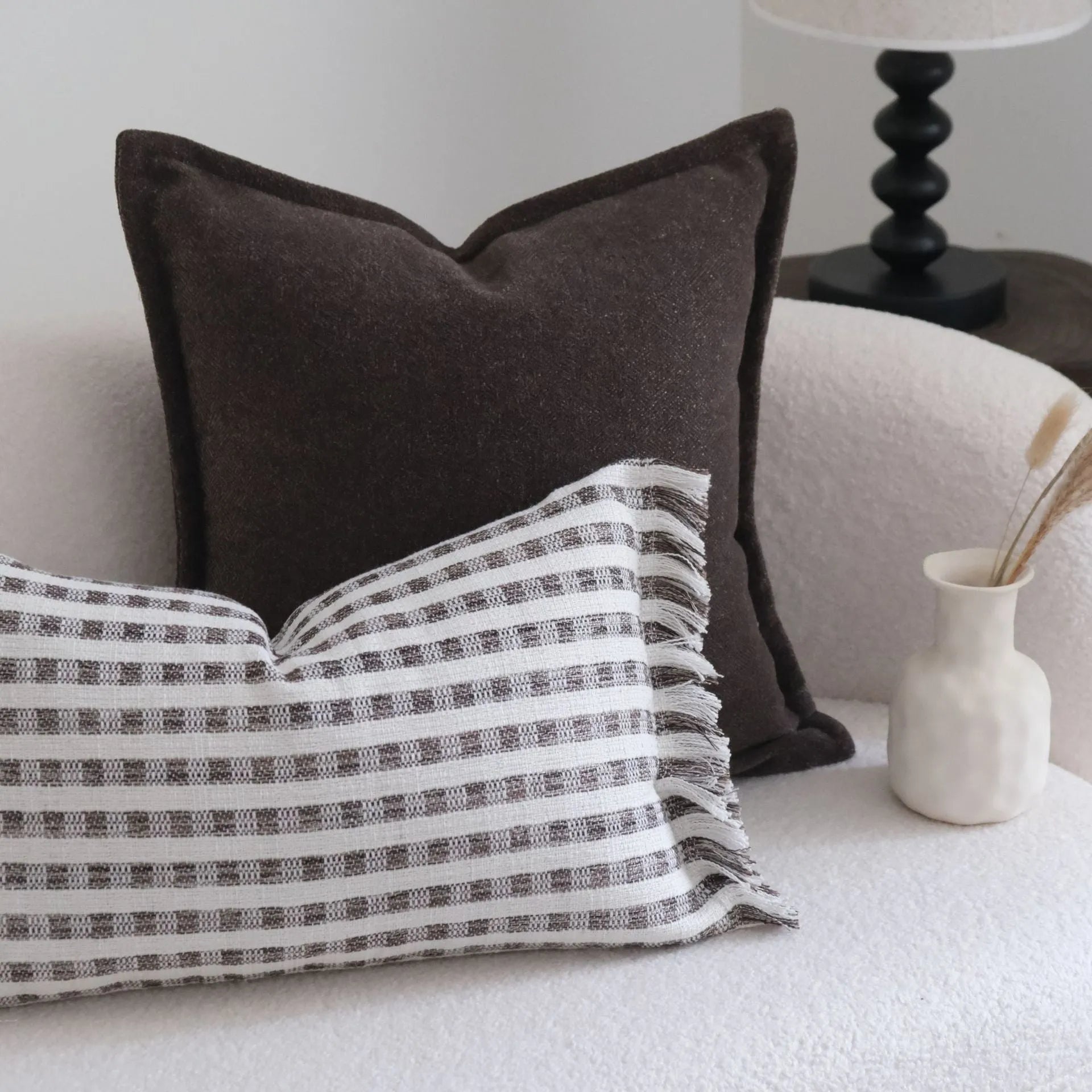 Coffee brown Chinese classical style cushion with striped and patchwork designs on a sofa.