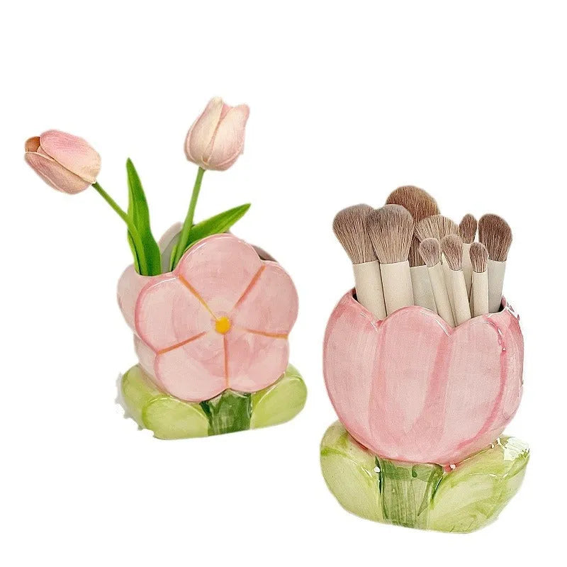 Ceramic pen holder box with floral decoration on a desk, holding pens.