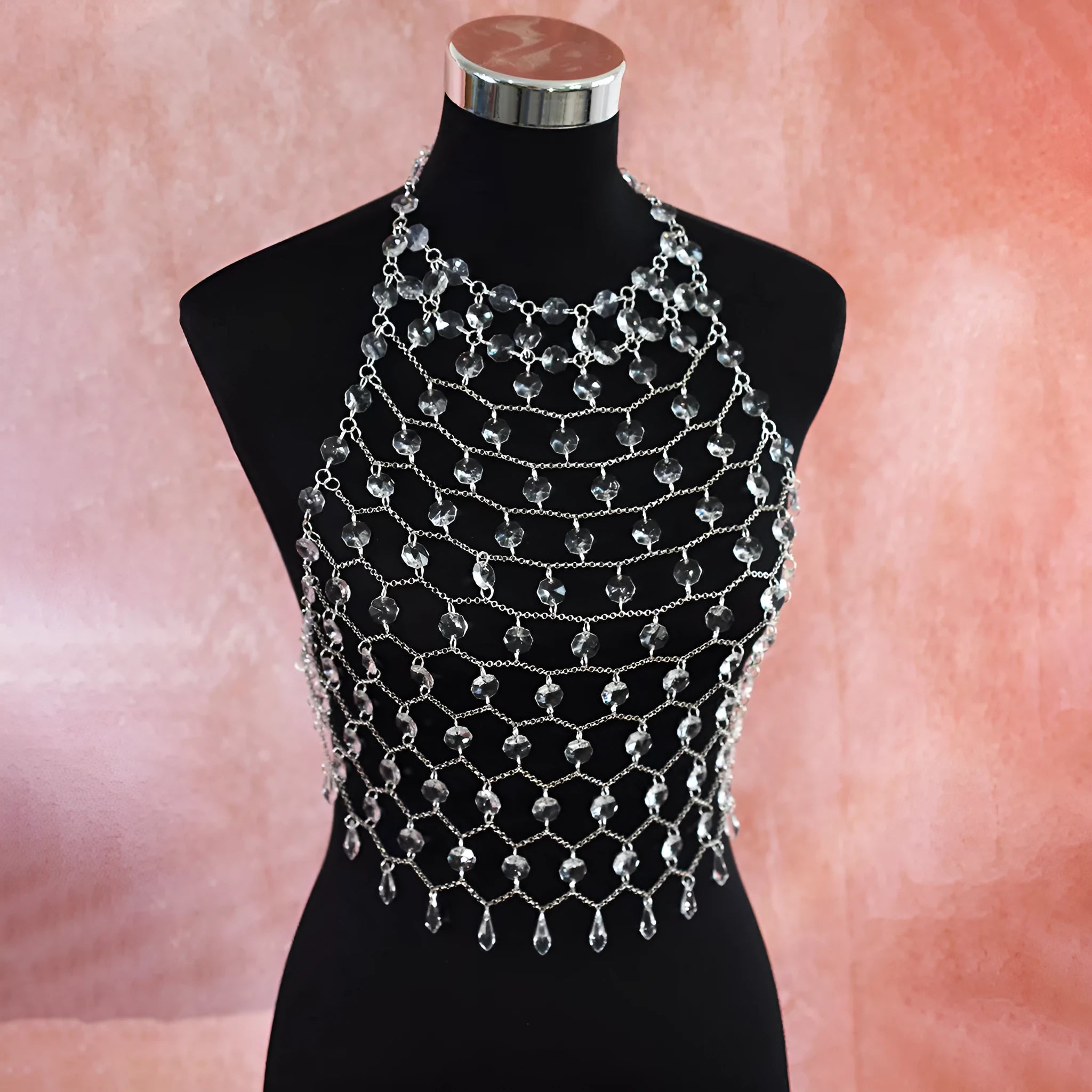 Hand-woven transparent acrylic sequinned plastic resin body chain draped flat.