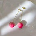 A pair of acrylic peach fruit earrings on copper posts, shown in small and large size options.
