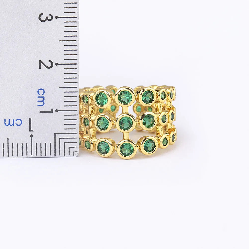 Wide copper ring with layered gold plating and green zircon stones
