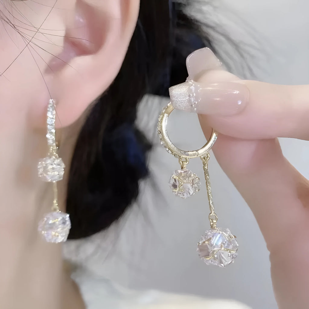 Silver drop earrings for women with a tassel ball and rhinestone ball pendant design.