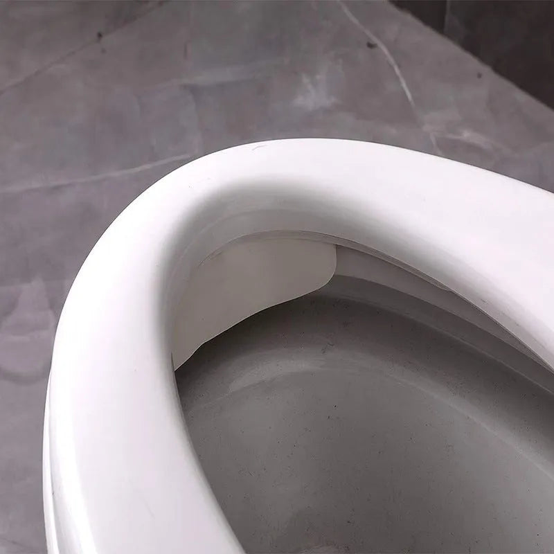 White plastic urine blocking board for toilet training placement on standard toilet bowl