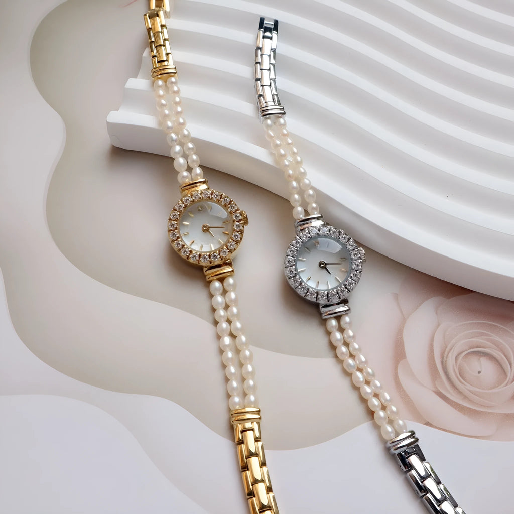 Women's light gold bracelet watch with natural freshwater pearls on a stainless steel strap, showing the 18mm round dial.