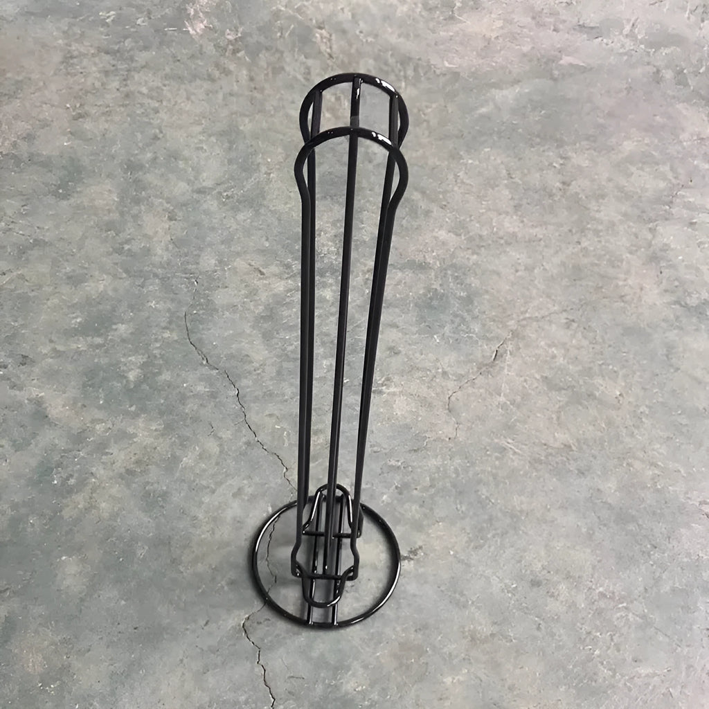 Black wrought iron coffee capsule storage rack holding pods on a kitchen counter