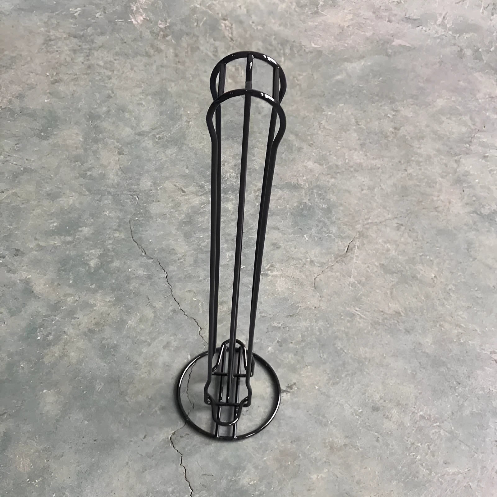 Black wrought iron coffee capsule storage rack holding pods on a kitchen counter