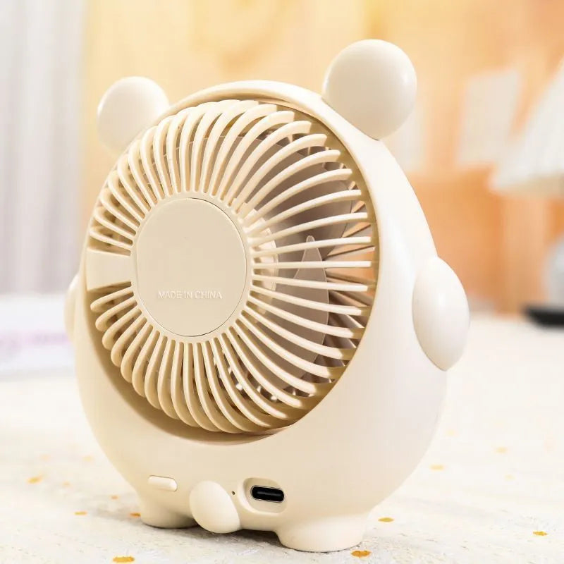Cute dog-themed USB desktop electric fan on a wooden desk, showing three-speed buttons and a light pink puppy design.