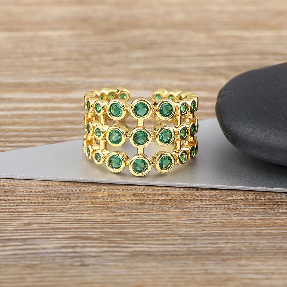 Wide copper ring with layered gold plating and green zircon stones