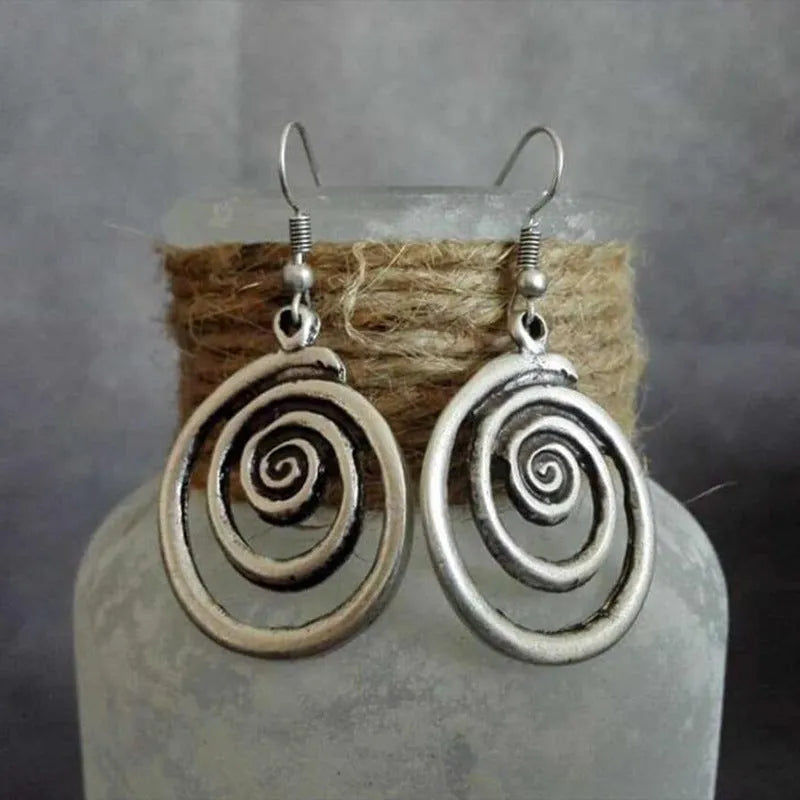 Silver geometric spiral earrings with distressed finish showing 2.6cm width and 5cm length