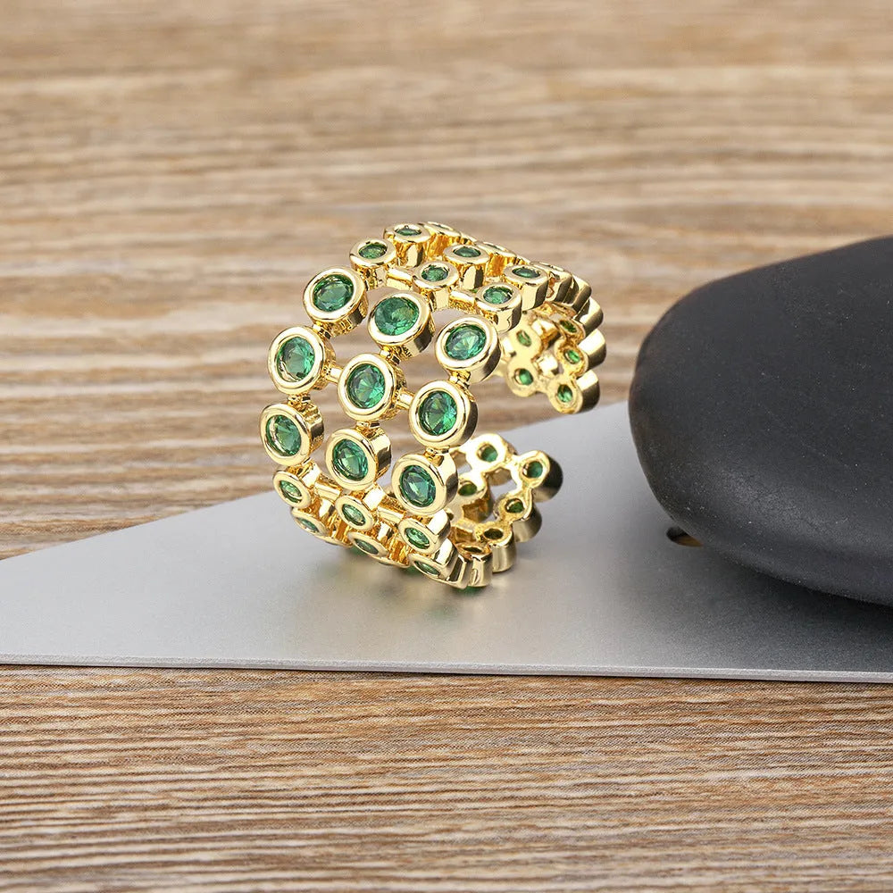 Wide copper ring with layered gold plating and green zircon stones