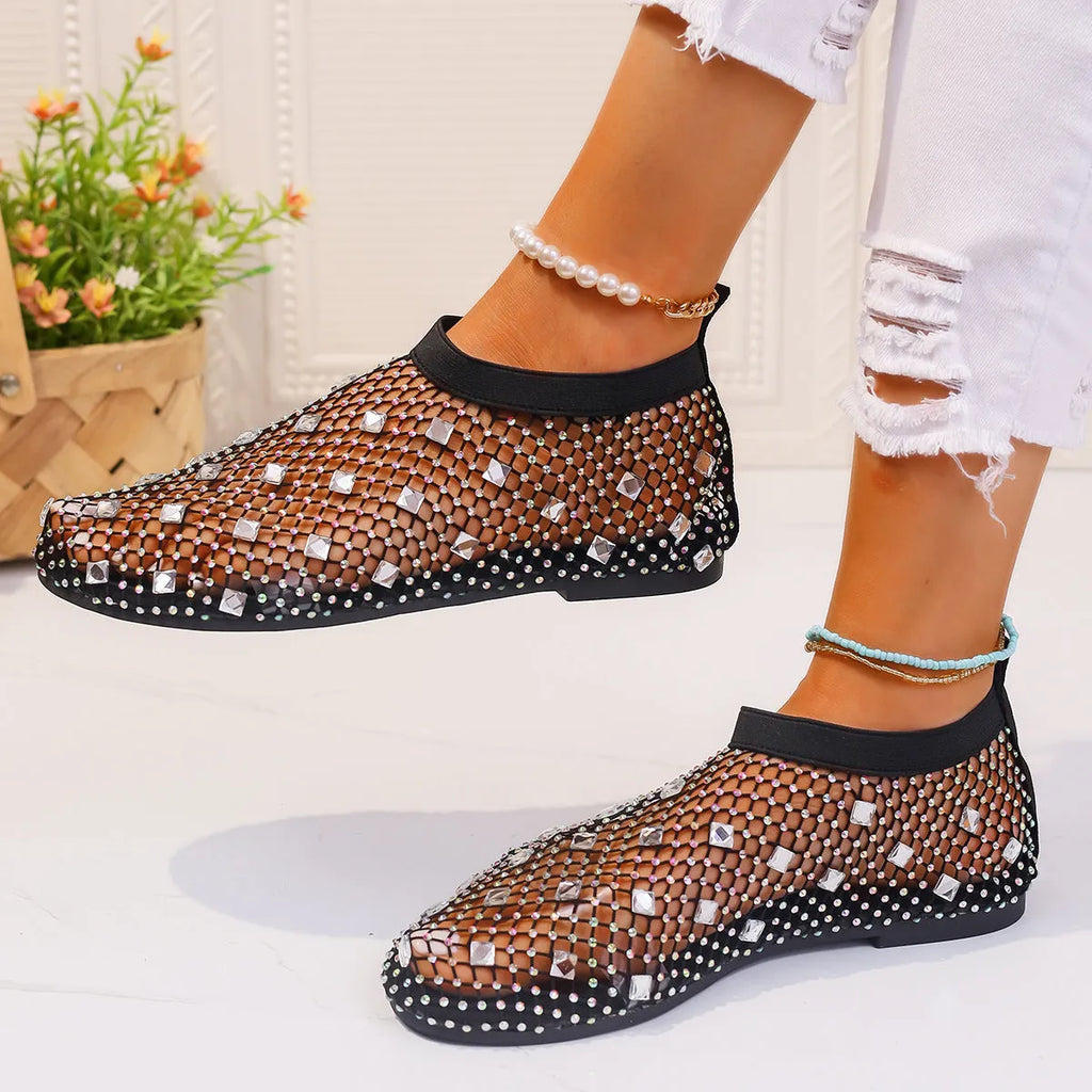 Women's flat sandals with colourful rhinestones on a breathable mesh upper and rubber sole.