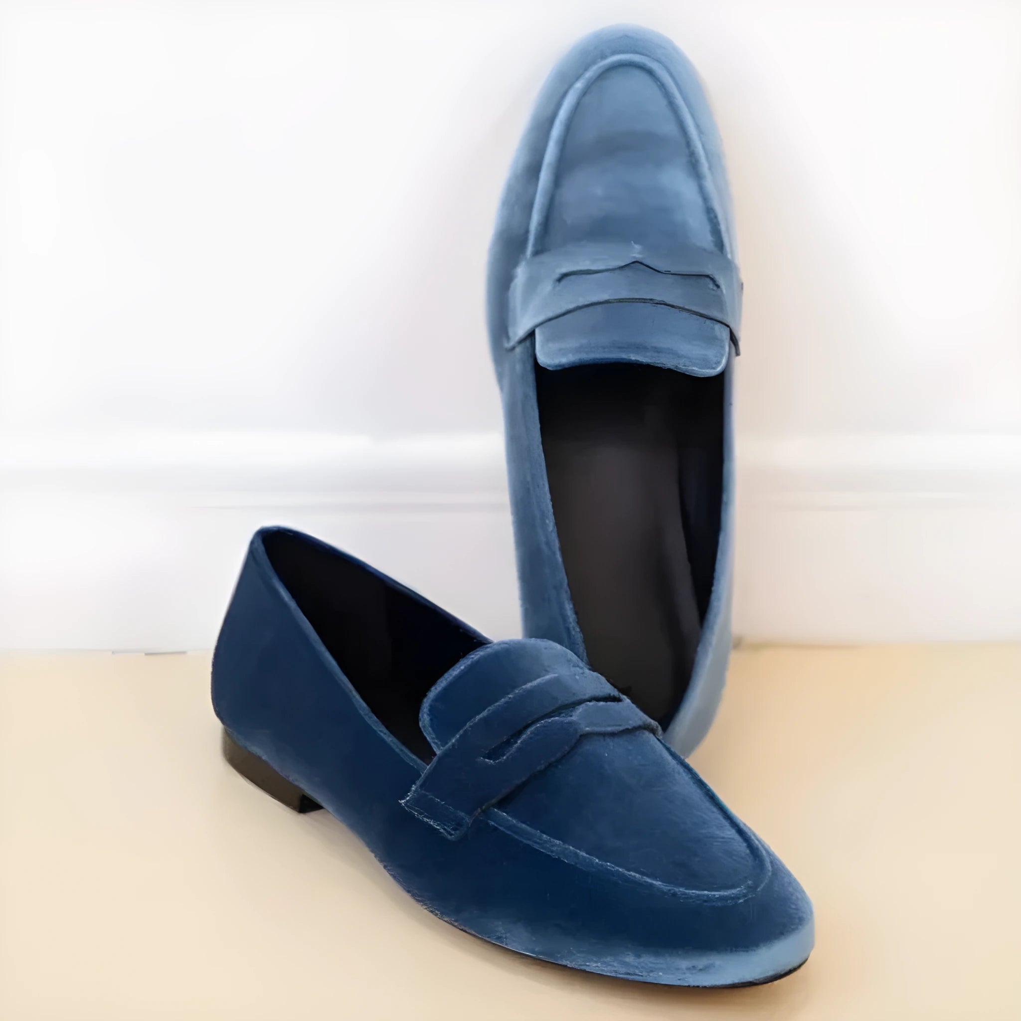 Blue artificial suede flat loafers with a black rubber sole, shown in a plus size range.