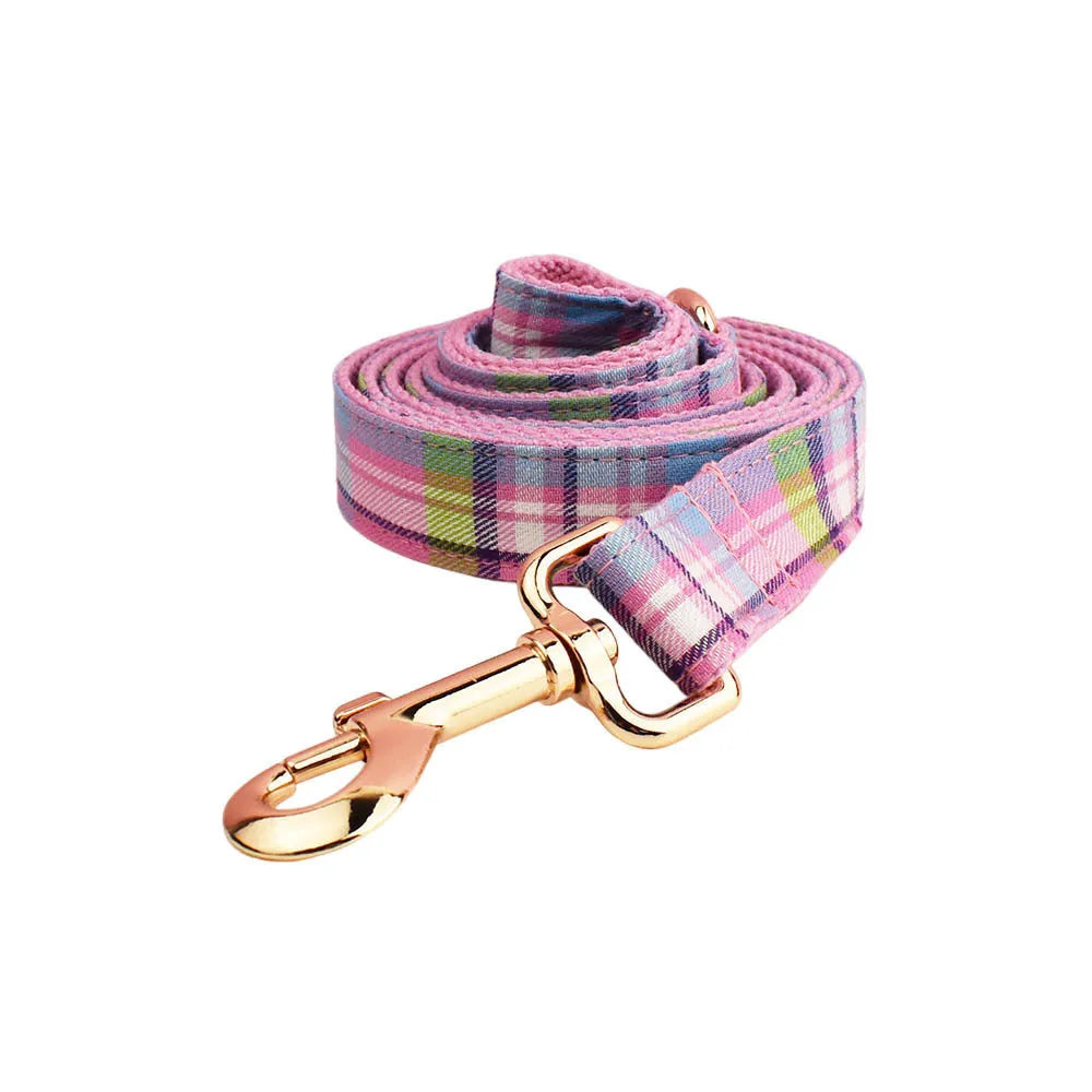 Qicaigei four-piece cloth dog collar, leash, vest, and bow set laid flat, showing assorted colour options.