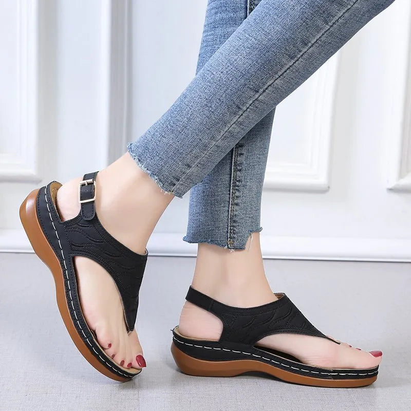 Women's black casual wedge heel sandals with an adjustable buckle strap on ankle.