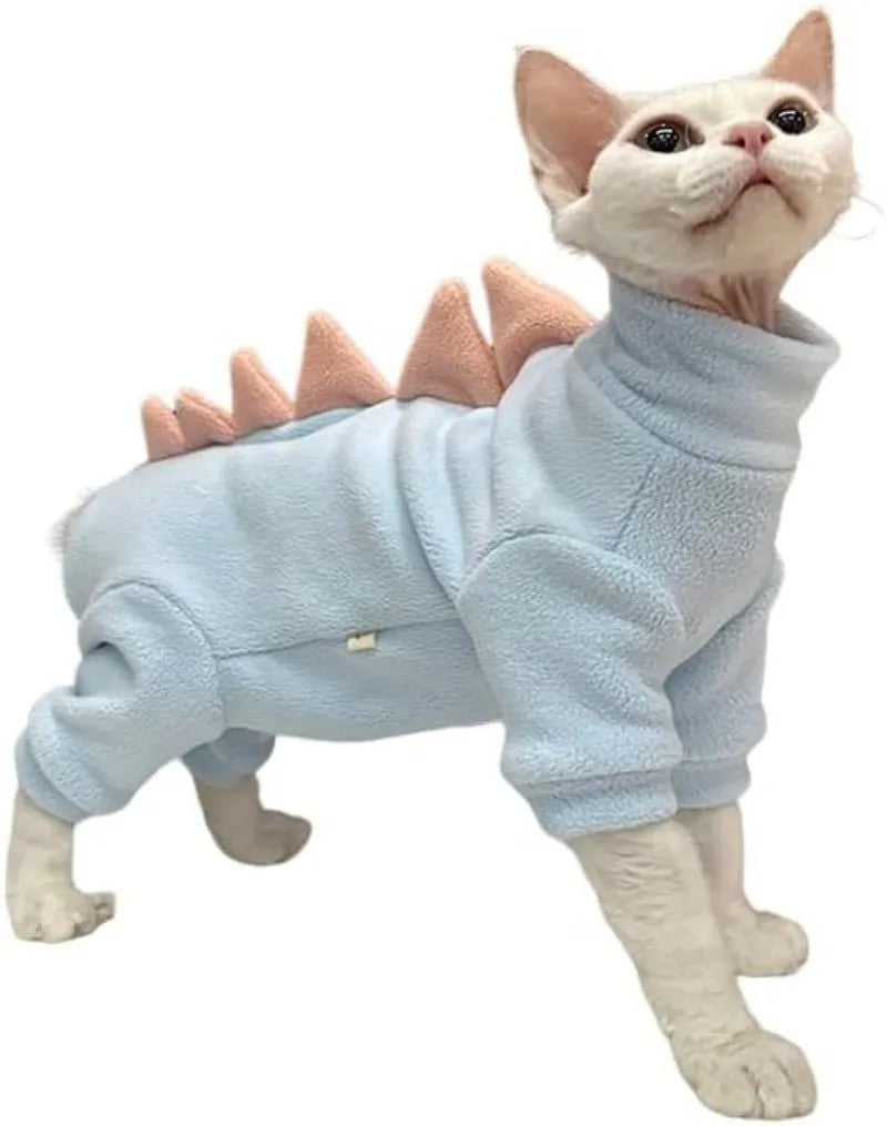 Sphynx cat wearing a green fleece dinosaur costume with a tail and spine spikes