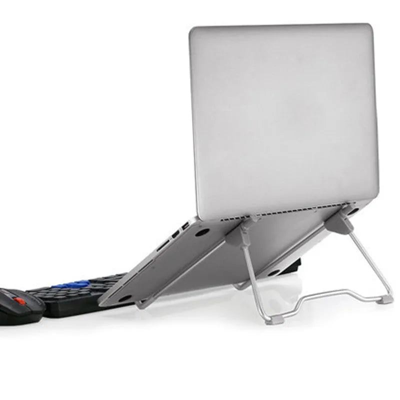 Grey adjustable angle aluminium alloy and plastic stand holding a mobile phone and a laptop on a desk.