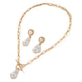 Gold-tone baroque pearl pendant necklace and matching stud earrings set on a white background.