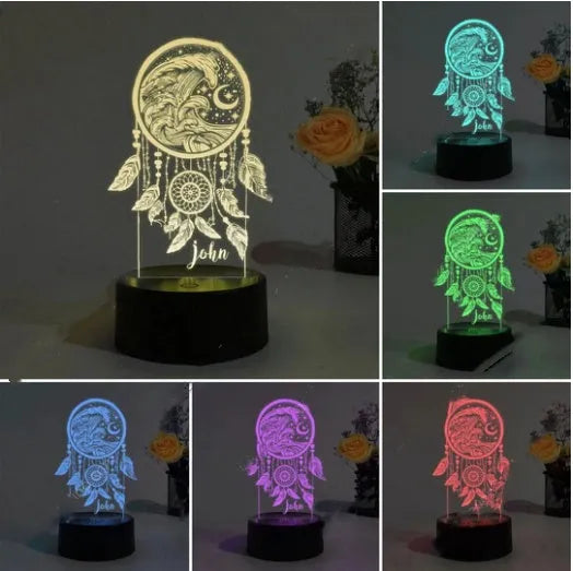 Black base dream catcher night light with acrylic shade and remote control on a wooden surface.