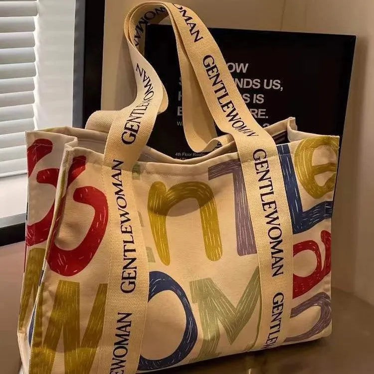 Canvas tote bag with printed design, available in black letters, coloured letters, and pattern style options.