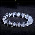 Women's white crystal pyramid bracelet with Ruyi symbol, showing polished beads.