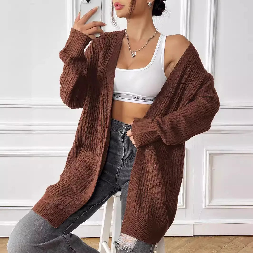 Dark green women's loose-fit acrylic cardigan with two pockets and long sleeves.