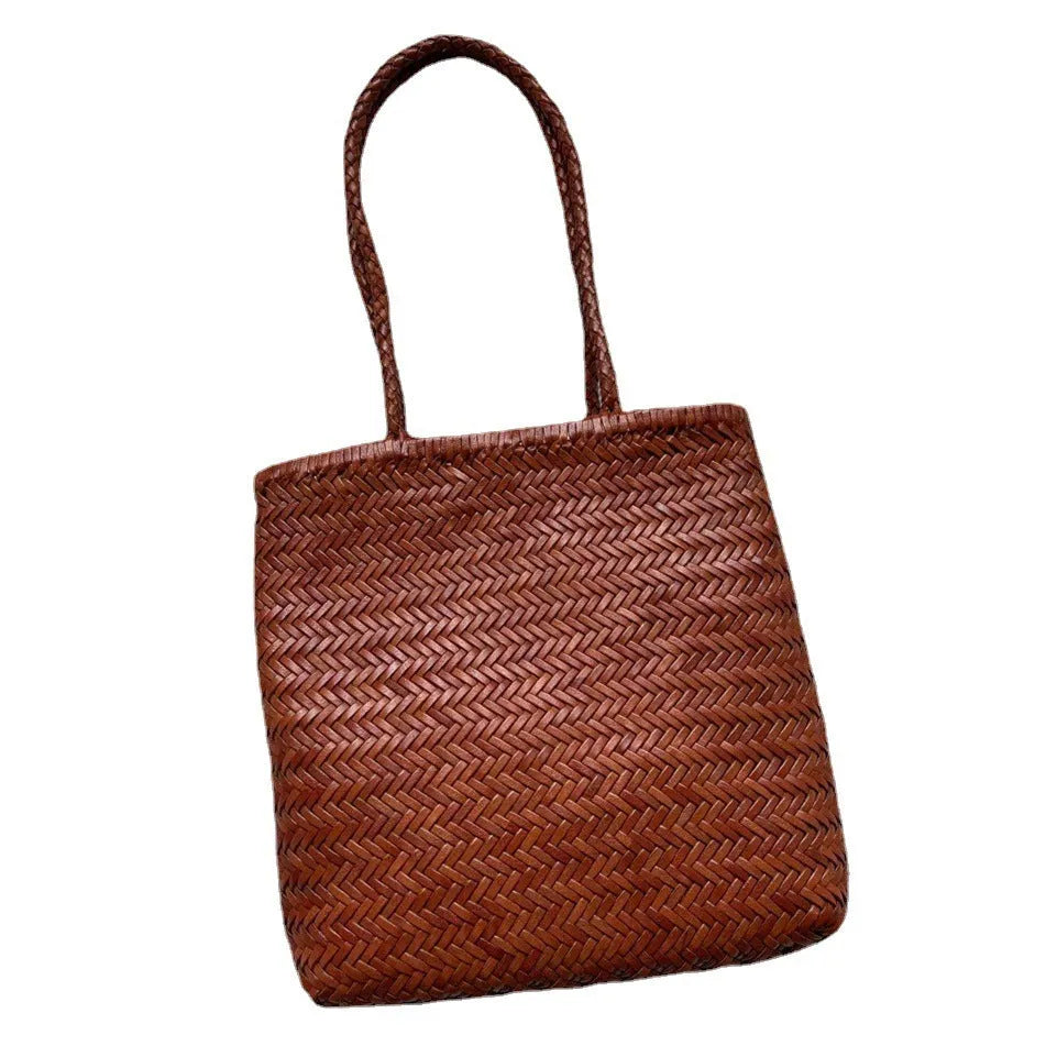 Brown handmade woven leather tote bag with a three-dimensional front pocket.