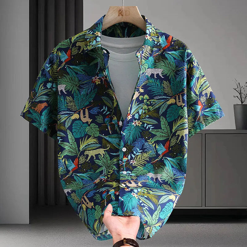 Man wearing a short sleeve cotton Hawaiian shirt with a blue and white floral print.