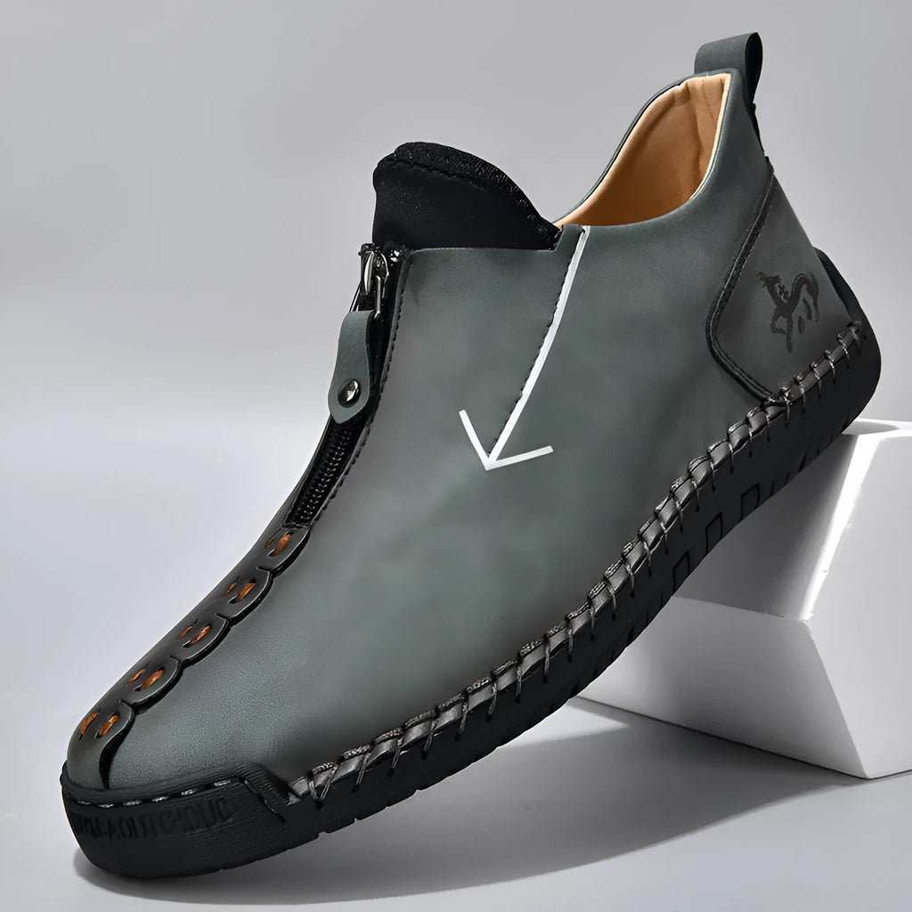 Men's brown leather-look zip-up ankle boots with hand-stitched detailing on a white background.