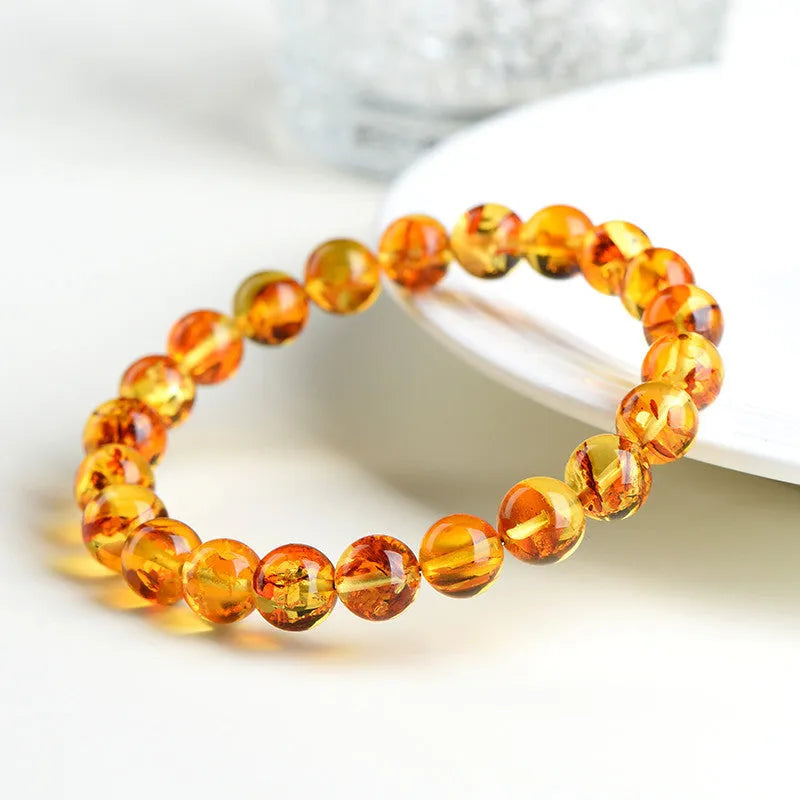 Natural yellow piebald amber geometric bracelet on a white background.