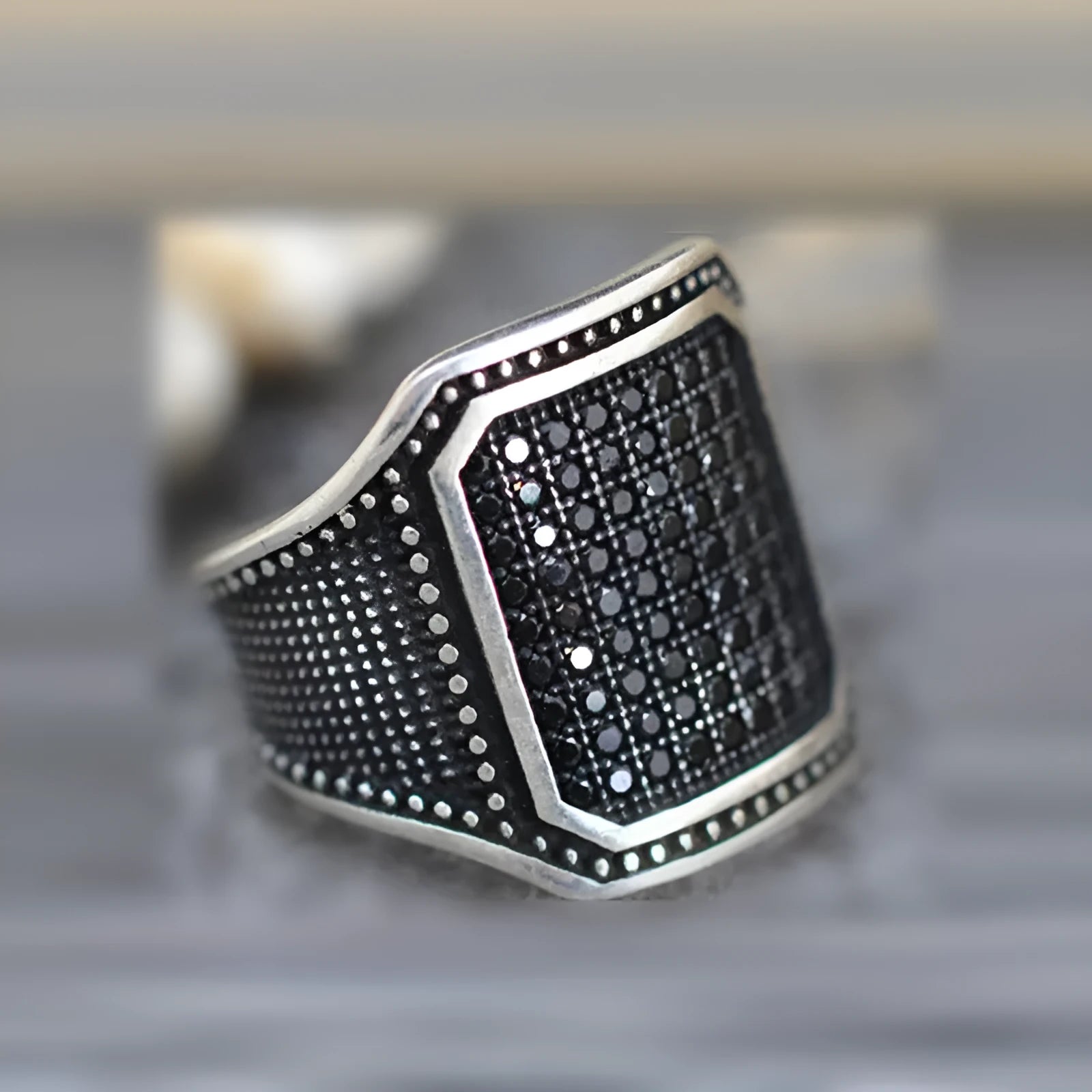 Black alloy ring with copper inlay and zircon stone, shown on a finger, size range 7 to 13.