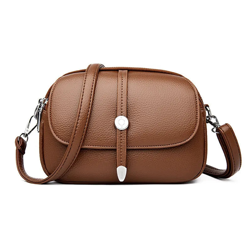Women's soft PU leather crossbody shoulder bag in oval suitcase shape, shown in black colour with decorative sewing thread detailing.