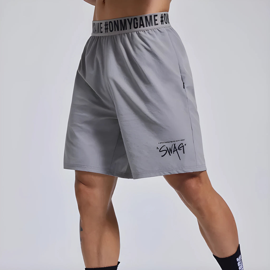 Men's black breathable sports shorts with letter detail and elastic waist.