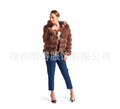 A woman wearing a loose-fit brown artificial fur hooded coat of medium length.