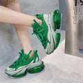 Women's green leather sports shoes with a thick translucent jelly sole and a white cross-tie strap.