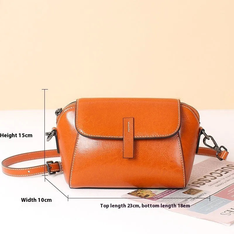Women's brown oil wax leather shell-shaped messenger bag with a cross-body strap and front sandwich pocket.