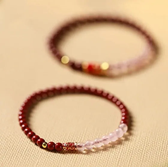 Hand-woven purple gold sand and strawberry quartz koi bracelet with crystal and pearl beads on a light background.