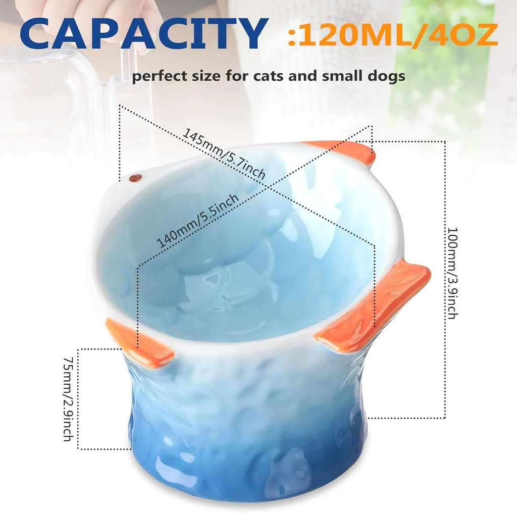 Set of blue fish-shaped ceramic cat bowls with a tilted angle on a wooden surface.