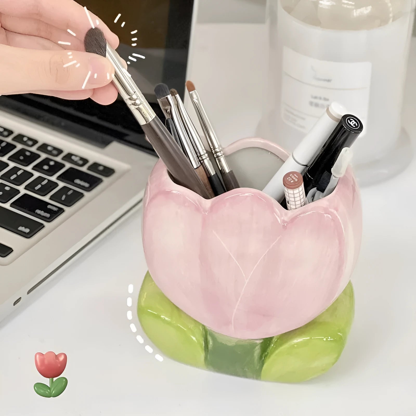 Ceramic pen holder box with floral decoration on a desk, holding pens.