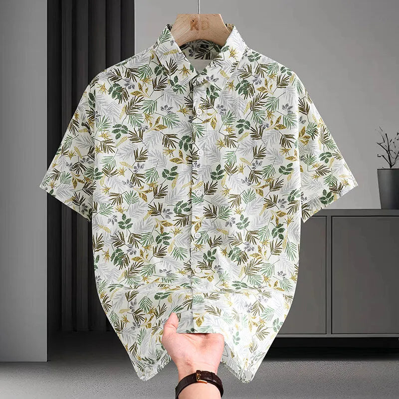 Man wearing a short sleeve cotton Hawaiian shirt with a blue and white floral print.