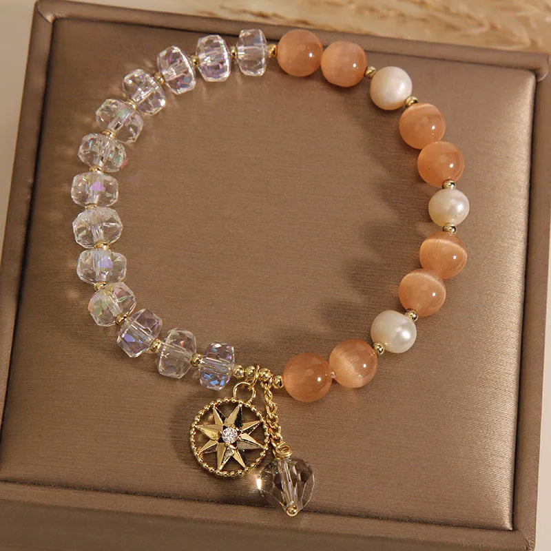 Gold-plated women's bracelet with an eight Awn star design and an orange crystal inlay.