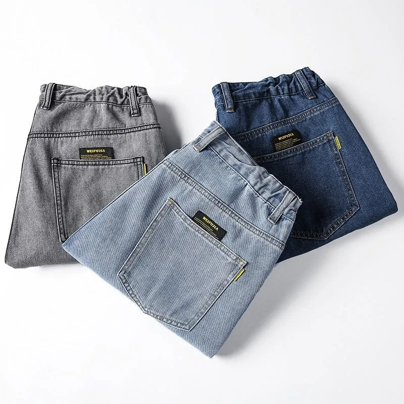 Man wearing dark blue loose straight-leg casual jeans with a mid-waist and zipper fly.