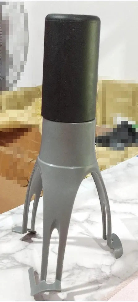 Green and grey automatic Stirr utensil for hands-free mixing in a cooking pot.
