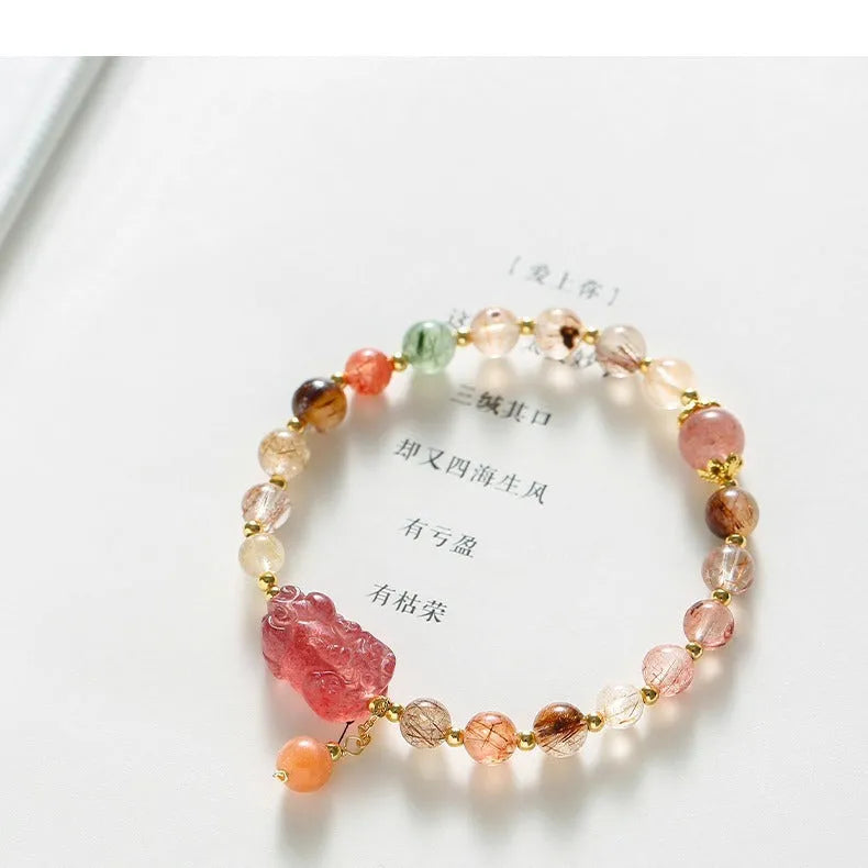 Women's copper bracelet with strawberry quartz crystal, Pixiu charm, and pearl beads.